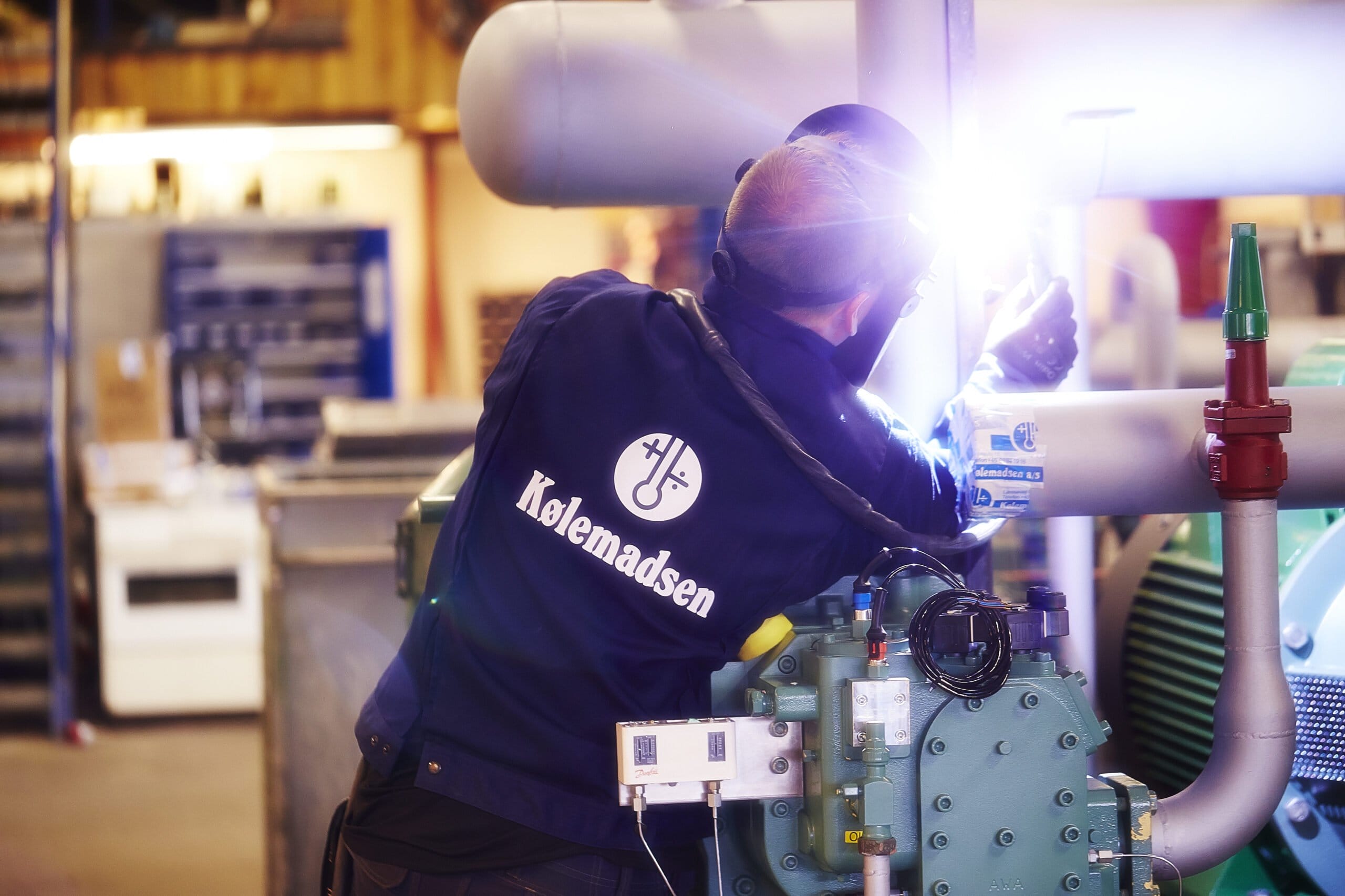 Tekniker svejser rør i industriværksted