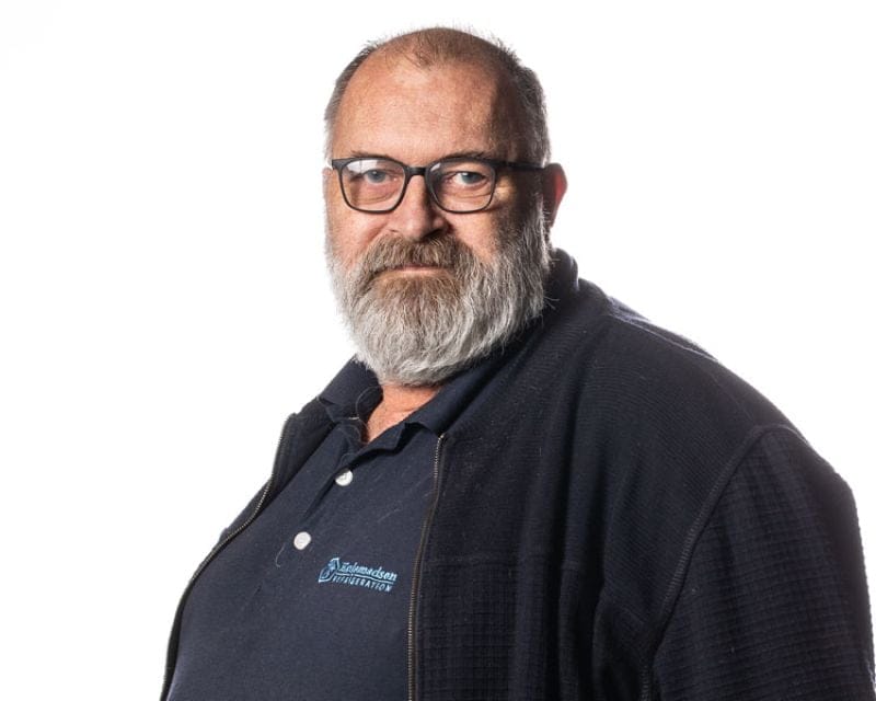 Mand med briller og skæg i mørkt tøj